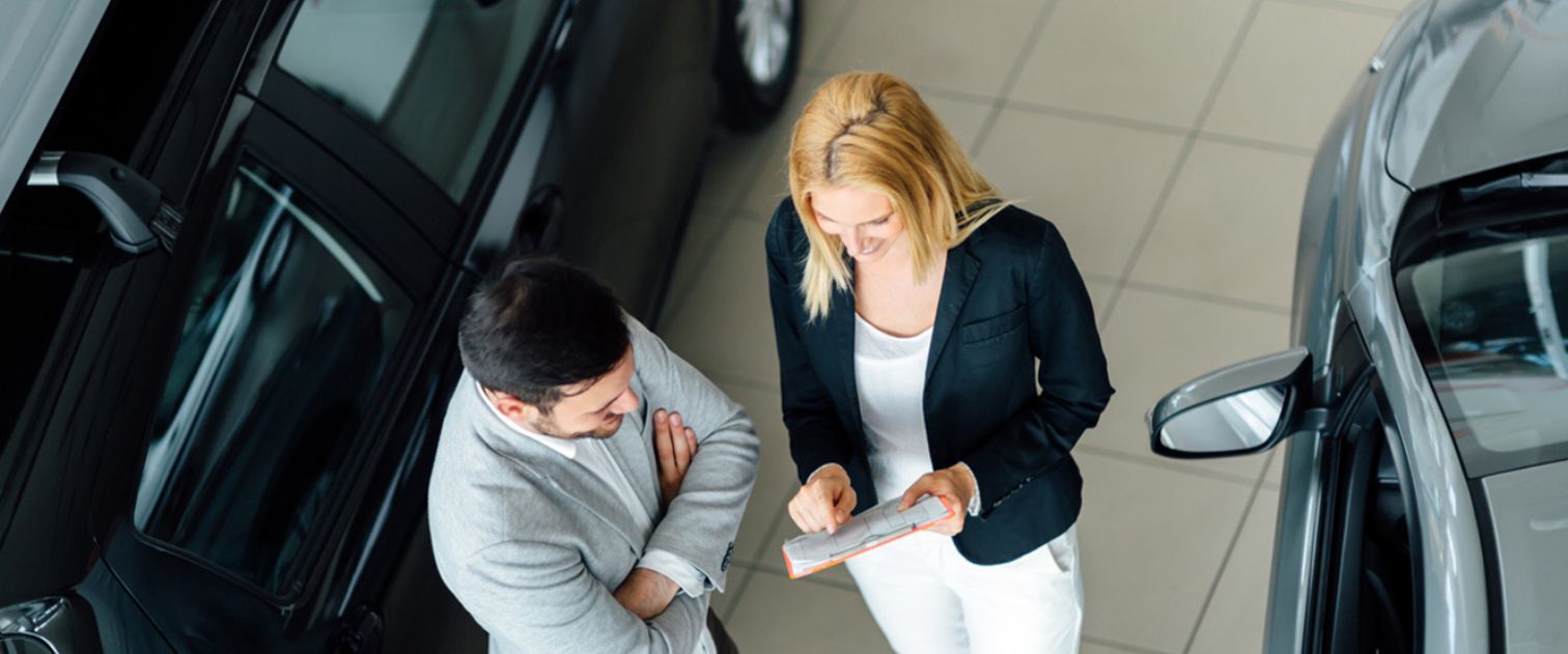 Kobieta i mężczyzna rozmawiają w salonie samochodowym