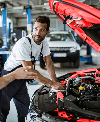 Mechanik rozmawiający nad uniesioną maską auta