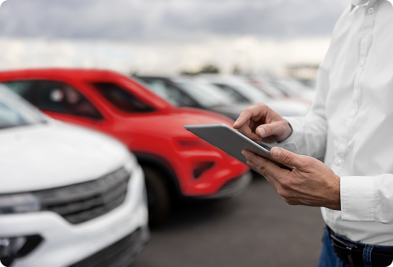 Mężczyzna korzystający z tabletu na tle salonu samochodowego