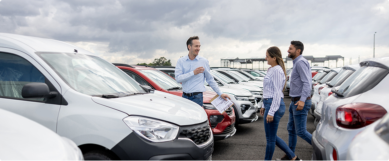 Mężczyzna prezentujący samochody parze na zewnętrznym parkingu