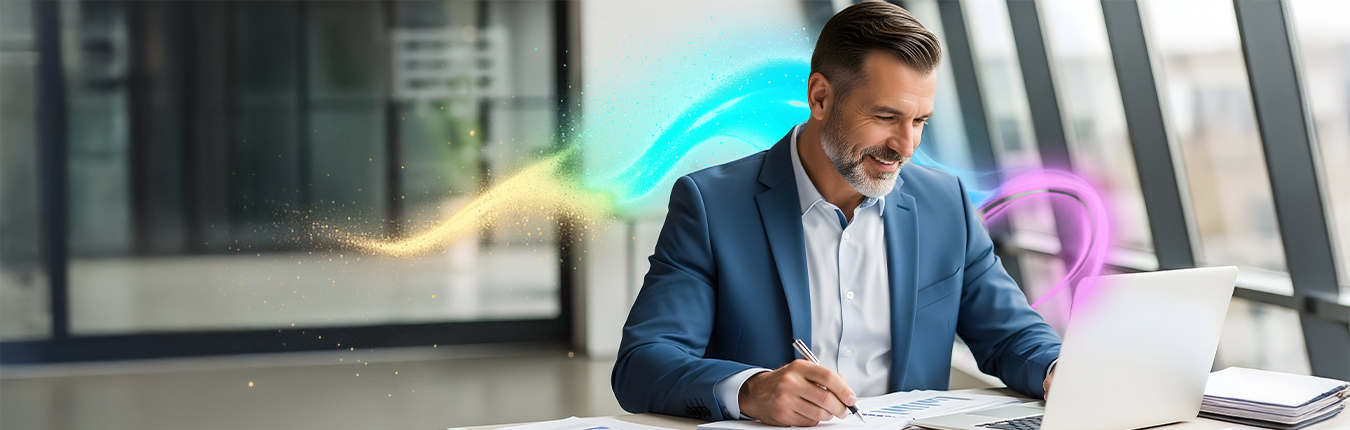 Uśmiechnięty mężczyzna w garniturze siedzi w biurze i uzupełnia dokumenty