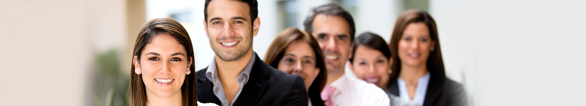 Grupa uśmiechniętych dorosłych ludzi w ubraniach biznesowych