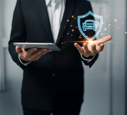 Stojący mężczyzna. W jednej dłoni trzyma tablet a nad drugą ręką pojawia się wizualizacja tarczy z samochodem w środku