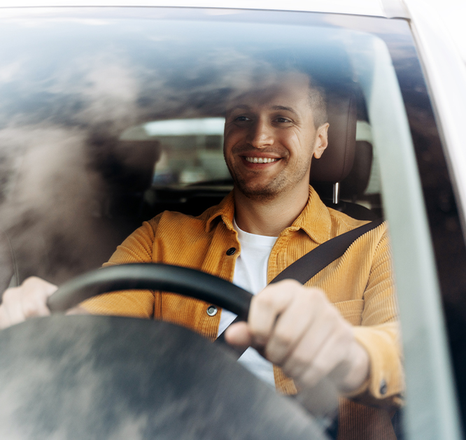 Uśmiechnięty mężczyzna prowadzący samochód