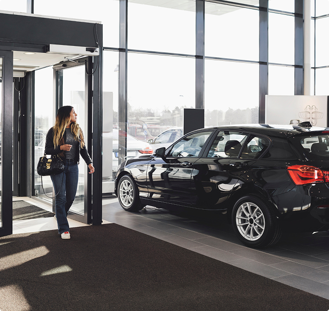 Kobieta wchodząca do salonu samochodowego