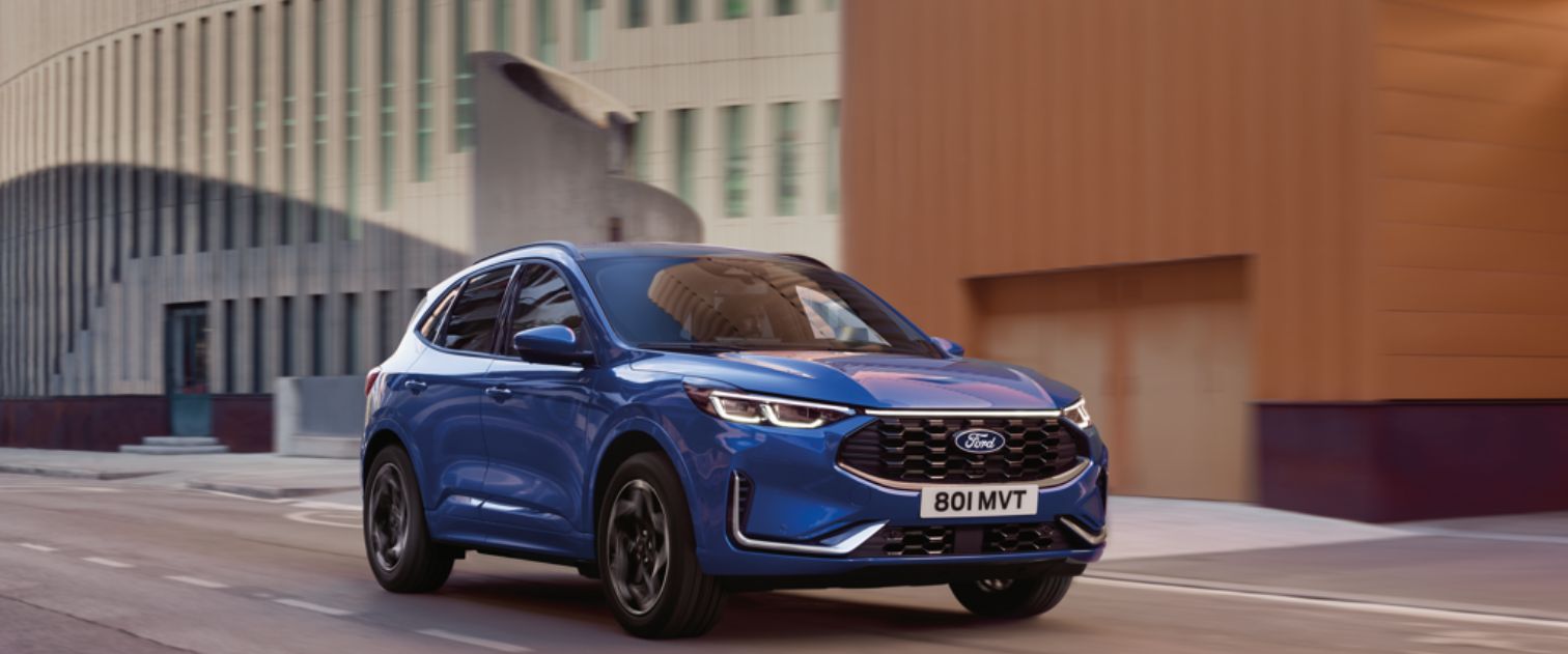 Granatowe auto marki Ford jedzie ulicą