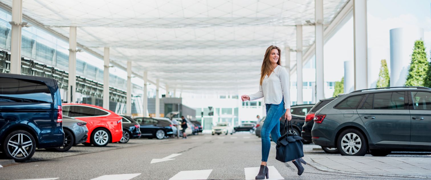 Kobieta przechodzi na pasach na parkingu